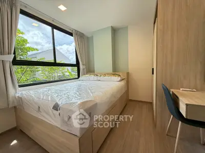 Modern bedroom with large window and stylish wooden furniture, offering a bright and cozy atmosphere.