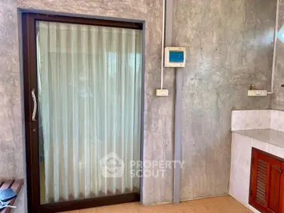 Modern interior with sliding glass door and textured concrete wall