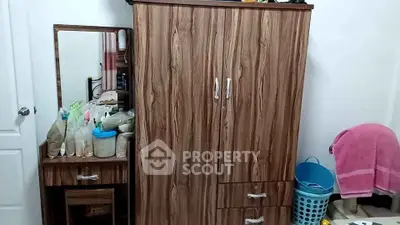 Cozy bedroom with wooden wardrobe and dressing table, perfect for organized living.