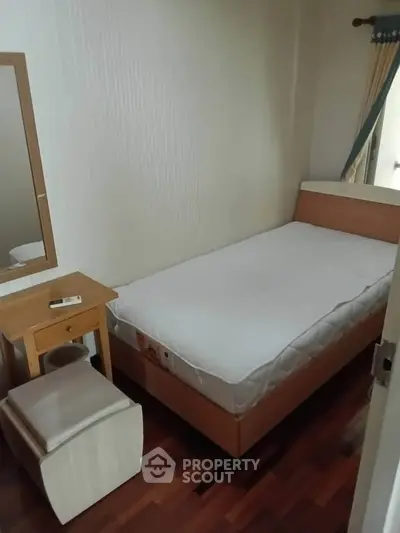 Cozy small bedroom with single bed and wooden furniture, perfect for minimalist living.