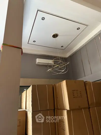 Modern interior with stylish ceiling light and stacked boxes, showcasing potential for versatile space usage.