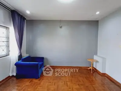 Spacious living room with blue sofa and wooden flooring