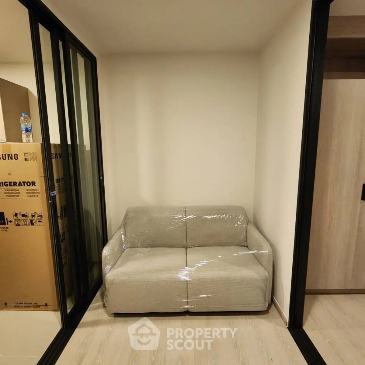 Cozy corner with a compact sofa and modern sliding doors in a stylish apartment.