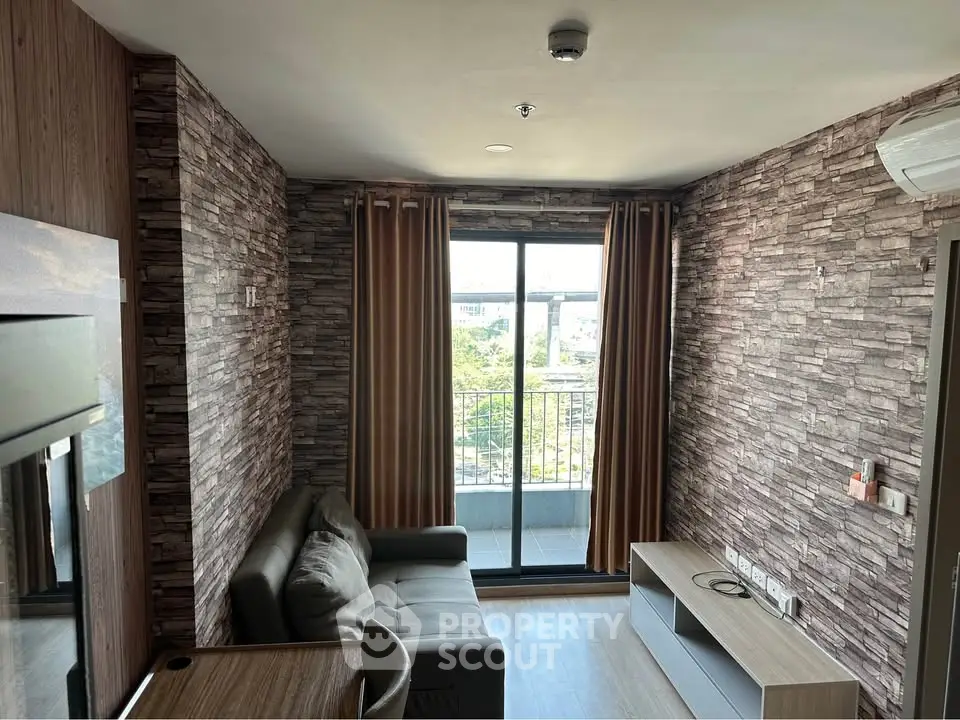 Modern living room with stone accent walls and balcony view in a stylish apartment.