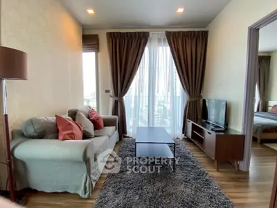 Modern living room with cozy sofa, stylish decor, and city view from large windows.