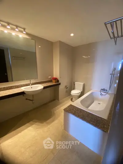Spacious modern bathroom with elegant fixtures and a luxurious bathtub.