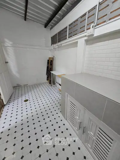 Spacious storage room with tiled floor and ample cabinet space