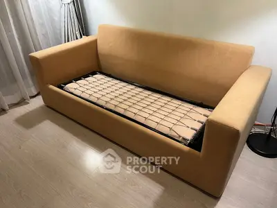 Modern sofa bed in a stylish living room with wooden flooring and elegant curtains.