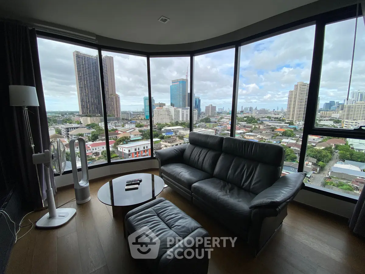 Luxurious living room with panoramic city views and modern leather furniture.