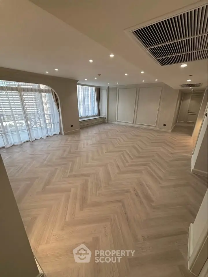 Spacious modern living room with elegant flooring and large windows