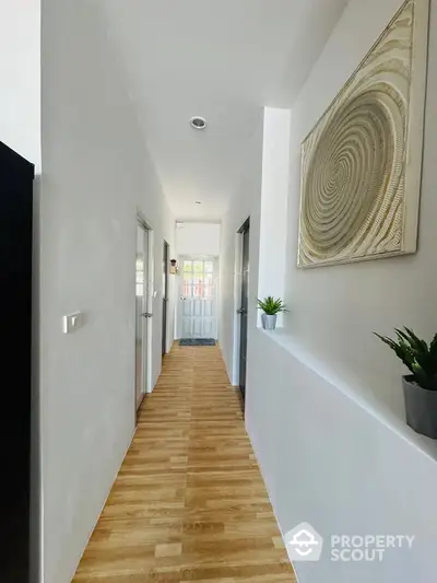 Modern hallway with wooden flooring and stylish decor in a contemporary home