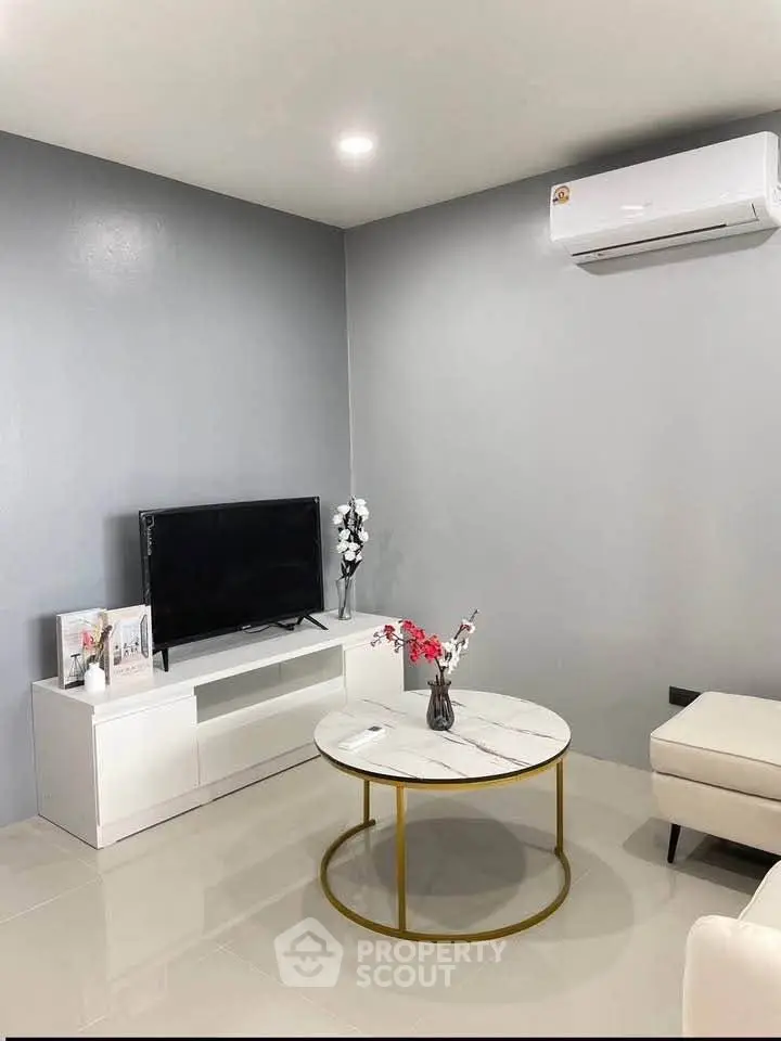 Modern living room with sleek furniture and air conditioning, perfect for relaxation.
