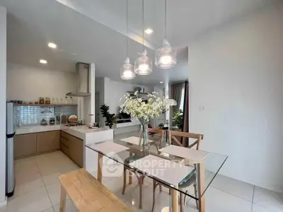 Modern kitchen and dining area with glass table and elegant lighting