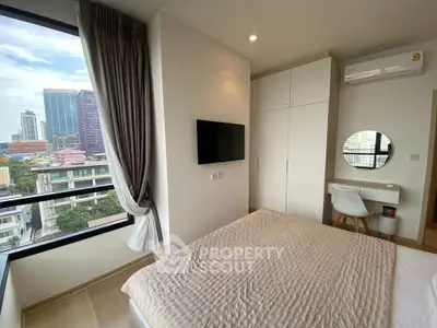 Modern bedroom with city view, featuring sleek furniture and ample natural light.