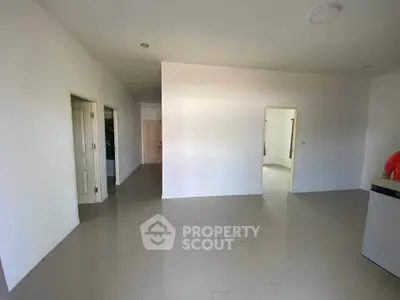 Spacious unfurnished room with white walls and tiled flooring, ideal for customization.