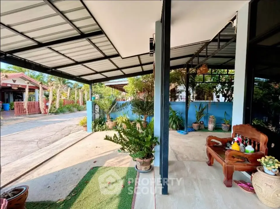 Charming outdoor patio with lush greenery and cozy seating area, perfect for relaxation and entertaining.