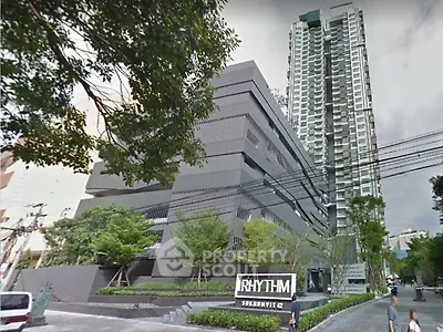 Modern high-rise building with lush greenery at Rhythm Sukhumvit 42, showcasing urban living in Bangkok.