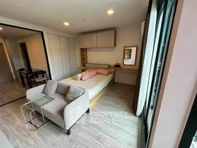 Modern bedroom with cozy seating and large windows in a stylish apartment