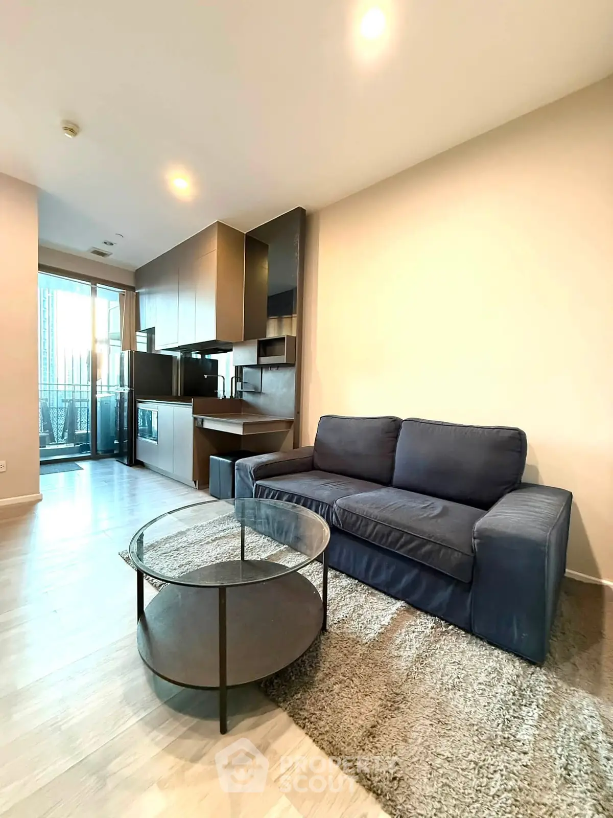 Modern living room with cozy sofa and sleek kitchen in open layout apartment