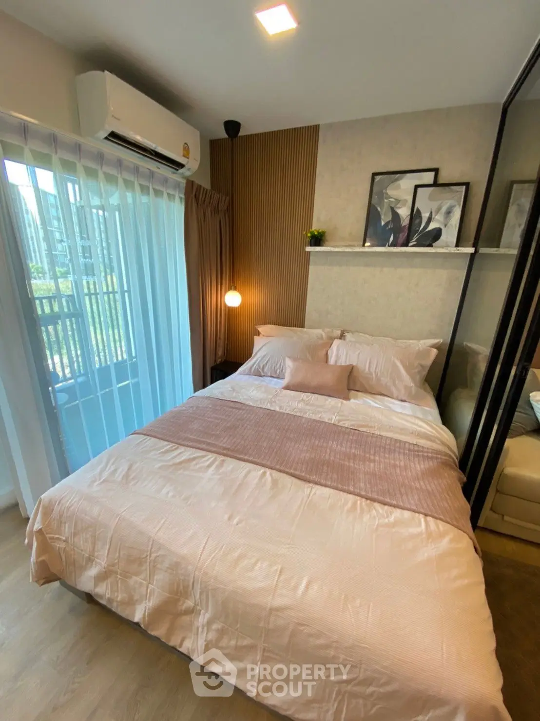 Cozy bedroom with modern decor and natural light from balcony view.