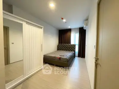 Modern bedroom with stylish bed and wardrobe, featuring elegant lighting and floor-to-ceiling curtains.
