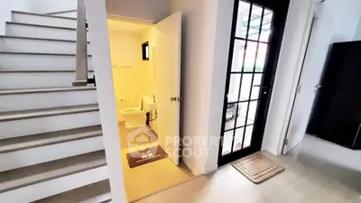 Modern home interior with staircase and bathroom, featuring sleek design and natural light.