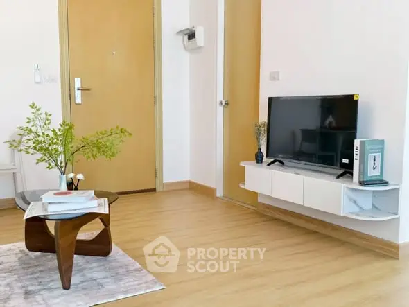 Modern living room with stylish furniture and mounted TV, showcasing minimalist design.
