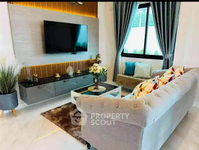 Luxurious living room with elegant decor and modern furnishings, featuring a plush sofa and wall-mounted TV.