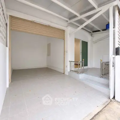 Spacious garage with tiled flooring and adjacent entrance in modern residential property.