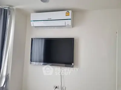 Modern living room with wall-mounted TV and air conditioning unit.