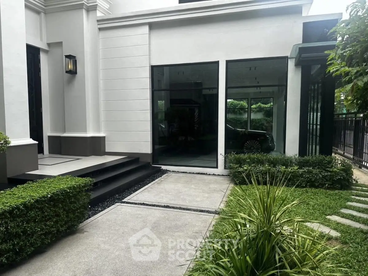 Elegant modern home exterior with lush garden and sleek glass windows