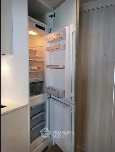 Modern kitchen with built-in refrigerator showcasing sleek design and ample storage space.