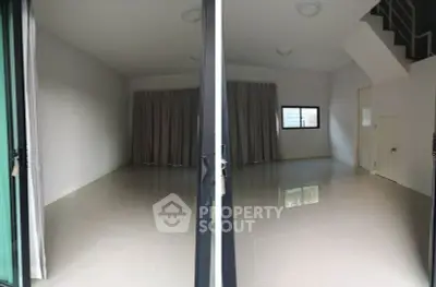 Spacious empty room with large windows and staircase, ideal for customization.