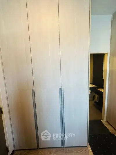 Modern storage area with sleek wooden cabinets and minimalist design.