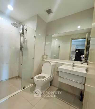 Modern bathroom with glass shower and sleek fixtures in a contemporary home.