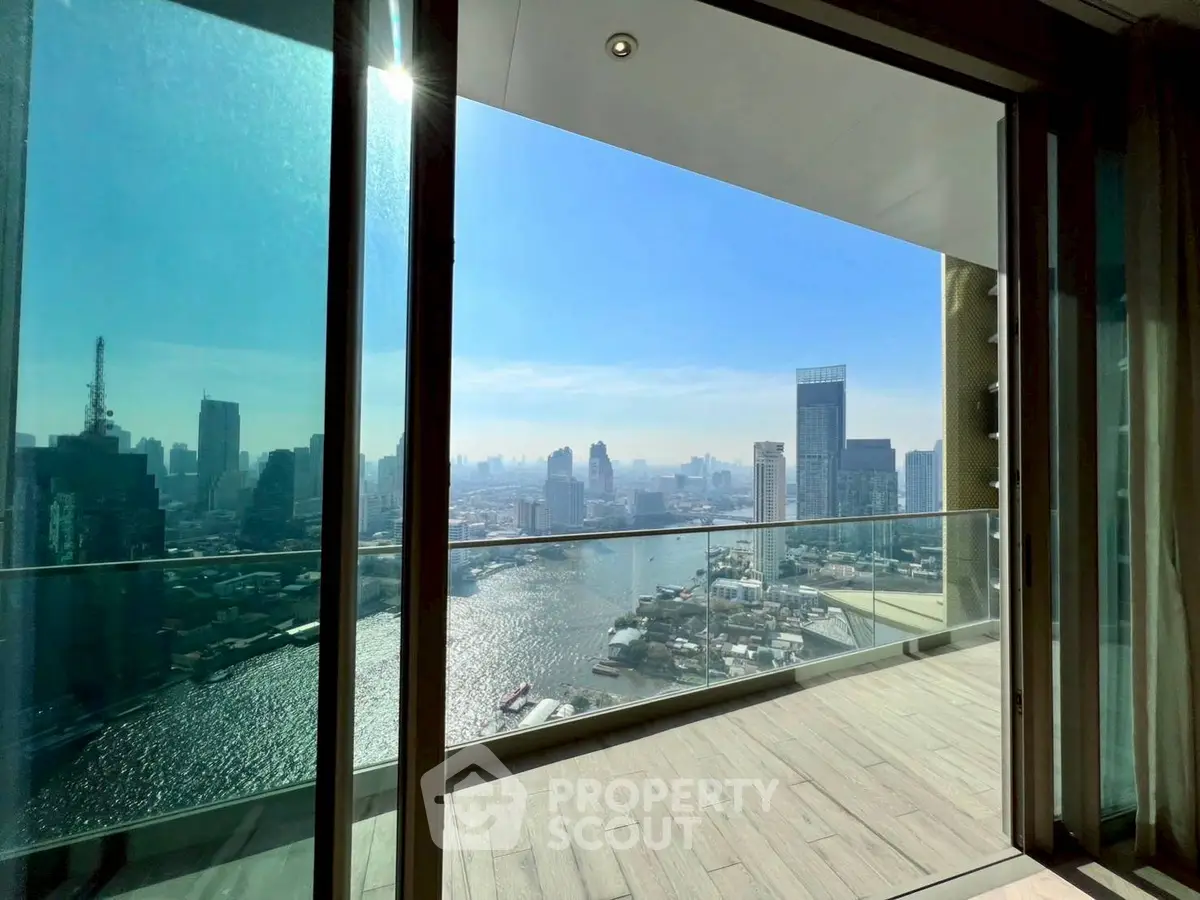 Stunning cityscape view from a modern high-rise balcony overlooking a river.