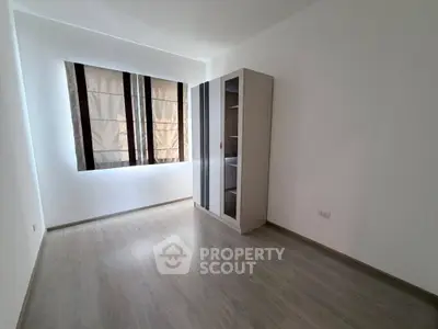 Spacious empty room with large window and modern wardrobe, perfect for customization.