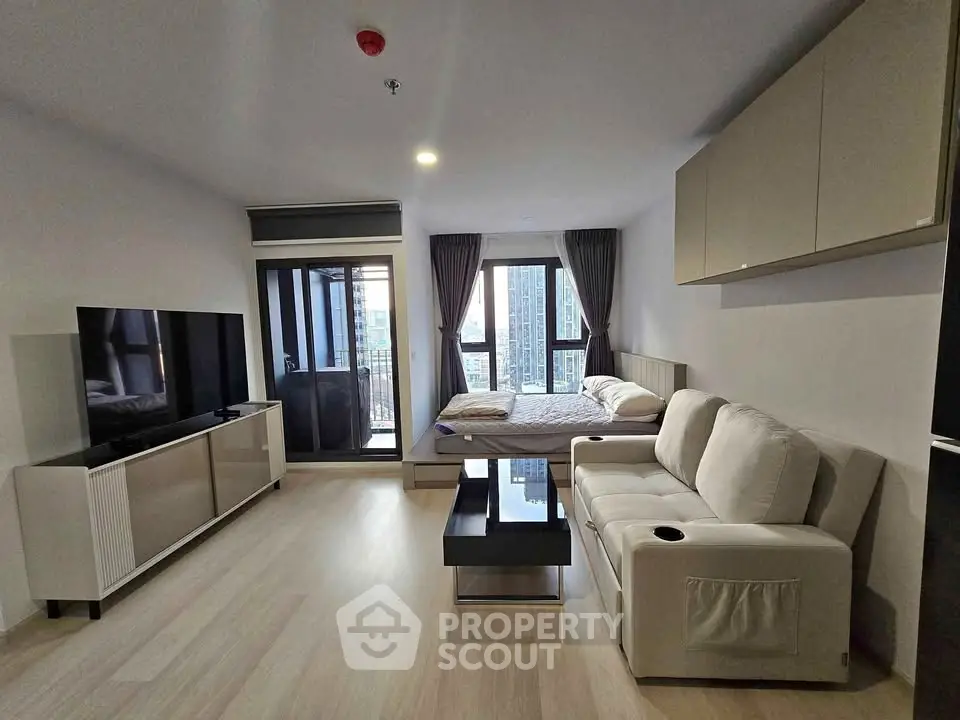 Modern studio apartment with sleek furniture and city view balcony, perfect for urban living.