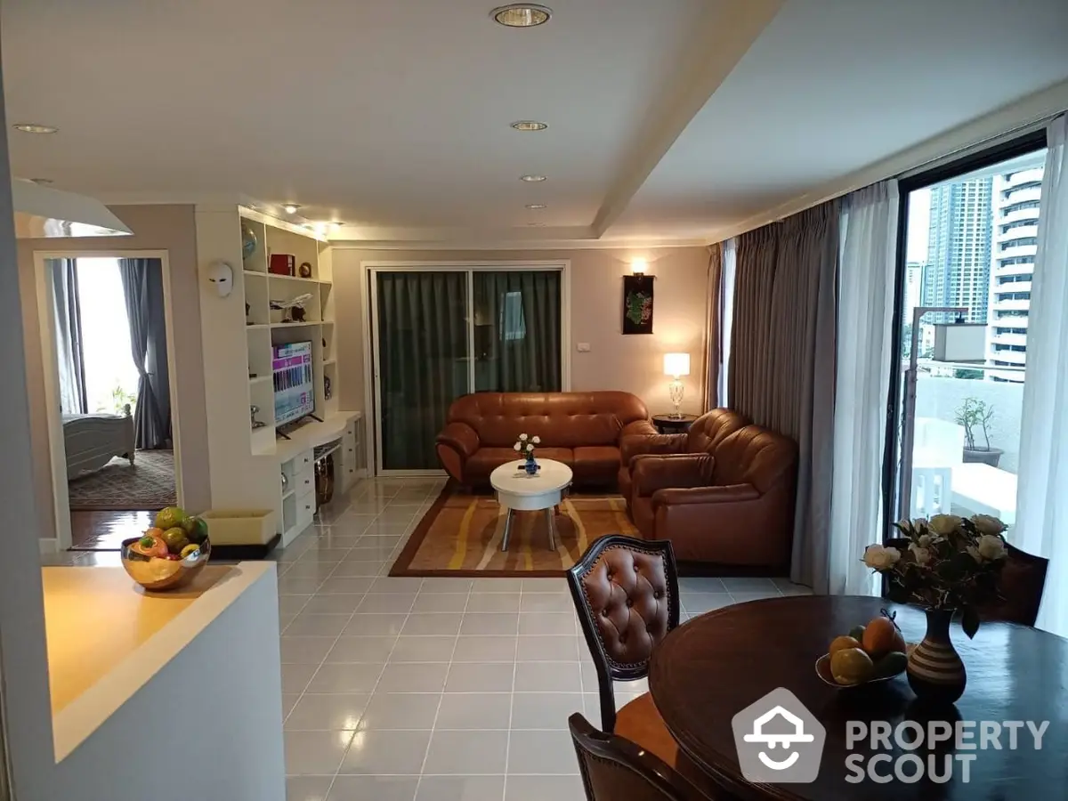 Spacious open-plan living area with gleaming white tiles, plush leather sofas, and a modern kitchen featuring state-of-the-art appliances, perfect for entertaining and relaxation.