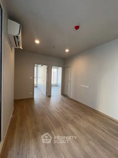 Spacious modern living room with wooden flooring and air conditioning