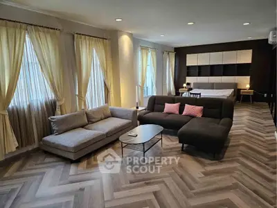 Spacious open-plan living room with modern decor and large windows for natural light.