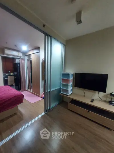 Modern studio apartment with sliding glass doors and wall-mounted TV