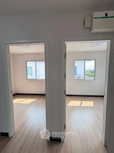 Bright and airy dual bedroom layout with natural light and modern flooring.