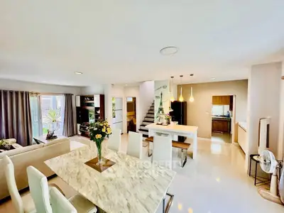 Spacious open-plan living and dining area with modern decor and natural light.