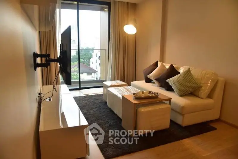 Modern living room with sleek decor and balcony view in urban apartment.