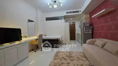 Modern living room with cozy sofa, TV, and stylish kitchen area