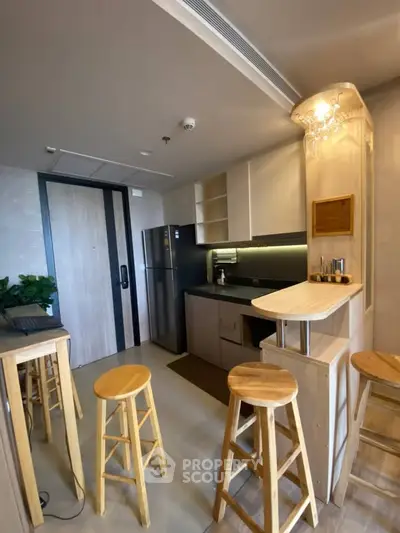 Modern kitchen with open layout and stylish bar stools in a contemporary apartment.