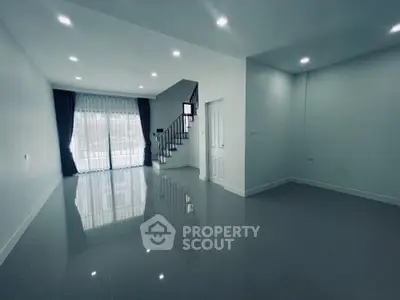 Spacious modern living room with glossy tiled floors and large windows