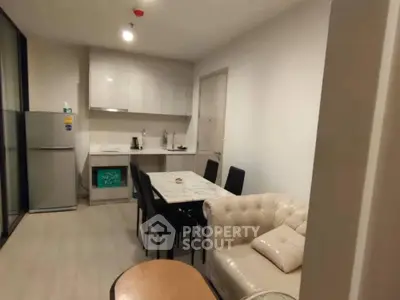 Modern kitchen with dining area and sleek furniture in a cozy apartment.