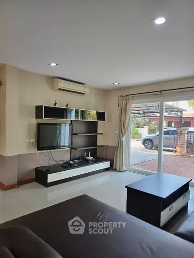Modern living room with sleek entertainment center and large window view